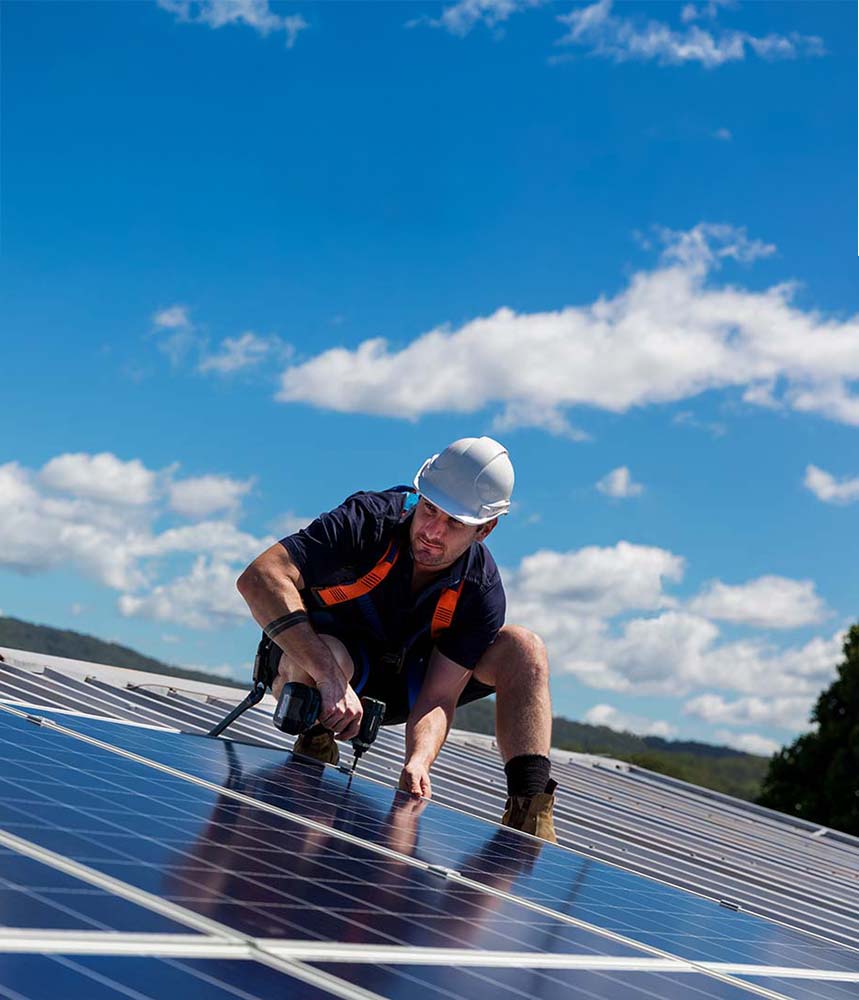 A solar installation technician performing maintenance on rooftop solar panels