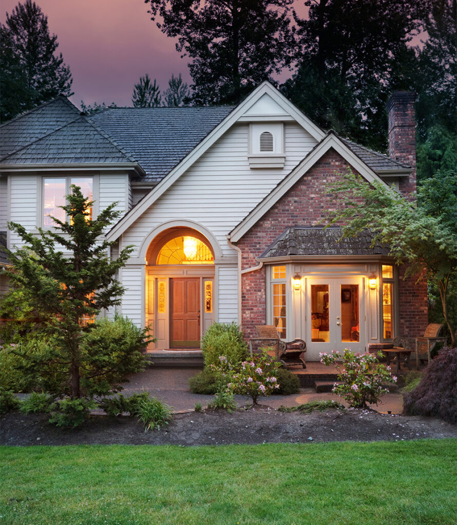 Home illuminated with lights at dusk - showcasing Current Energy's exceptional electrical services