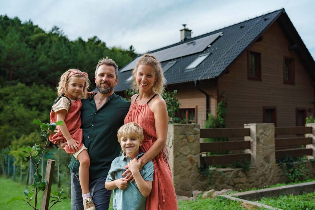 A family infront of the home with Solar Panels. This is an example of a home in Greenfield MA with a solar panel installation