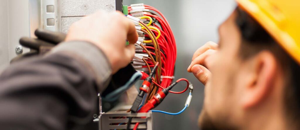 An electrician working on an electrical box