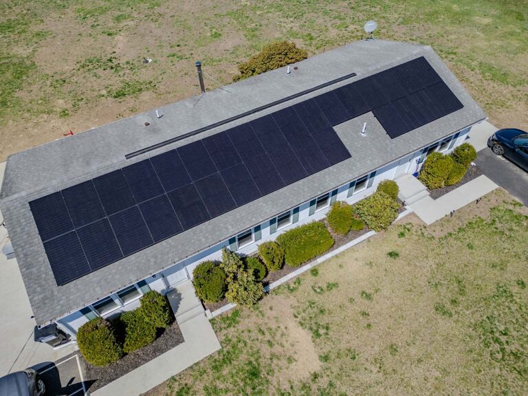 Aerial view of solar panels following a long roof slope, with a gap around a plumbing vent