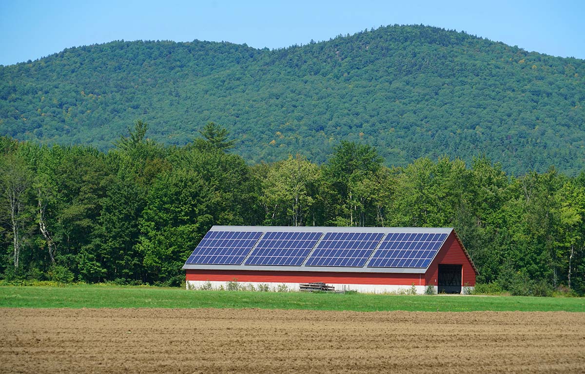 Farm building with rooftop solar panels in Vermont, an example of net metering in New England