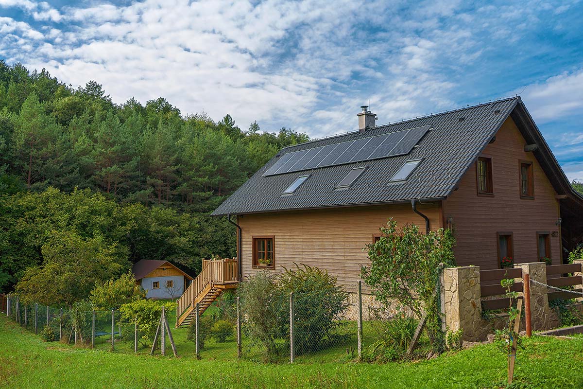 Solar panels on a rural hillside home surrounded by trees, showing how solar power supports energy independence in the hilltowns of Western Massachusetts.
