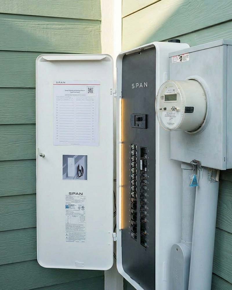Exterior SPAN smart panel shown open, illustrating the type of load-management equipment commonly integrated with solar and battery systems.