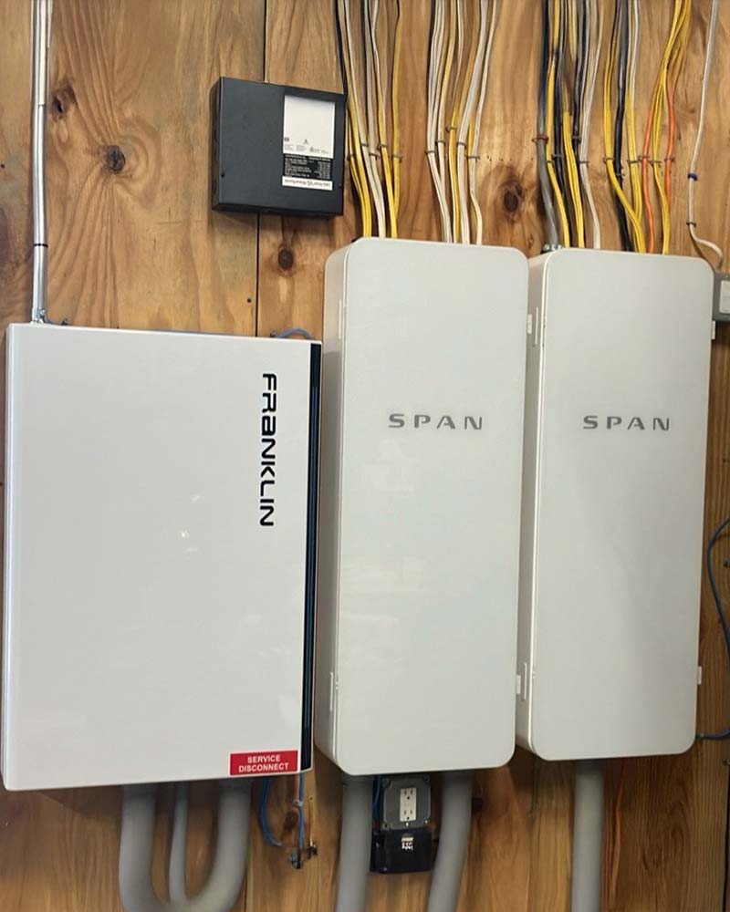 Franklin home battery installed alongside dual SPAN smart panels with exposed wiring neatly organized in Greenfield, MA.