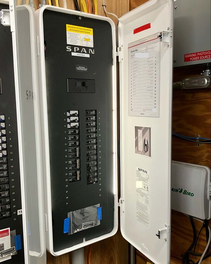 Open SPAN smart panel showing labeled breakers and internal components used for home energy management in Greenfield, MA.