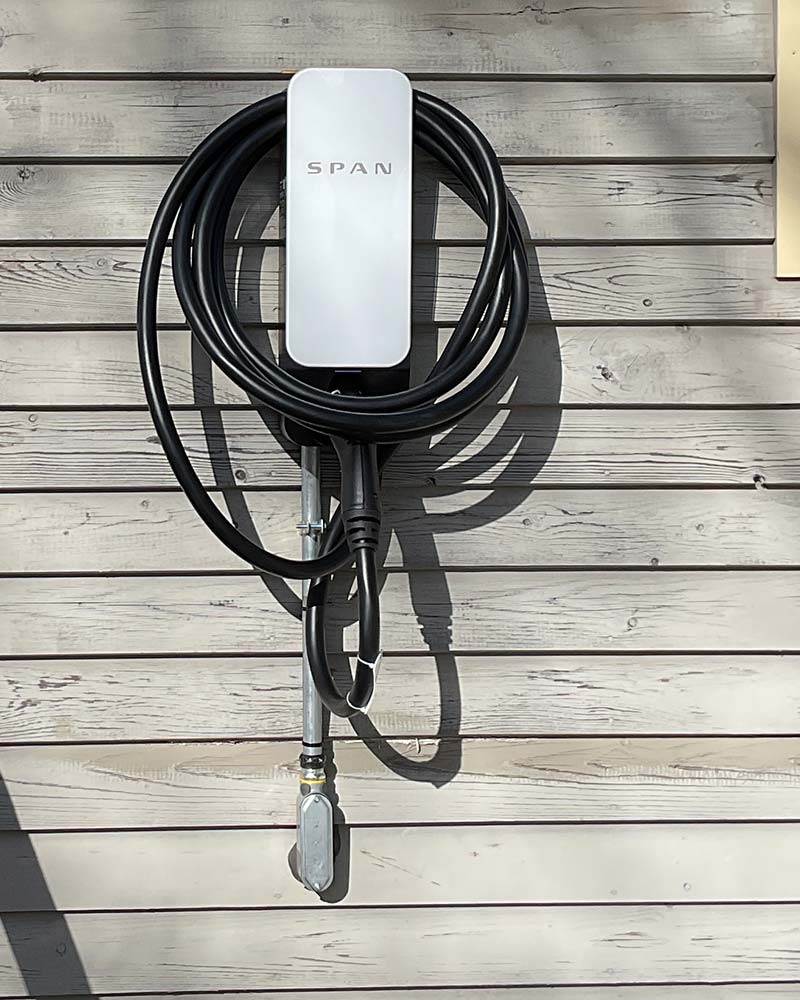 SPAN Level 2 EV charger on wood siding, typical of exterior charging solutions in Greenfield, MA.