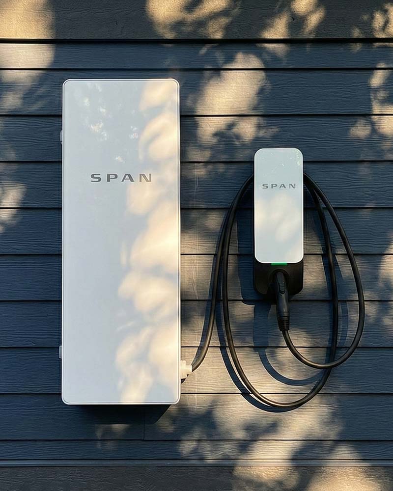 SPAN smart panel and charger on dark siding, an example of modern electrical services in Greenfield, MA.