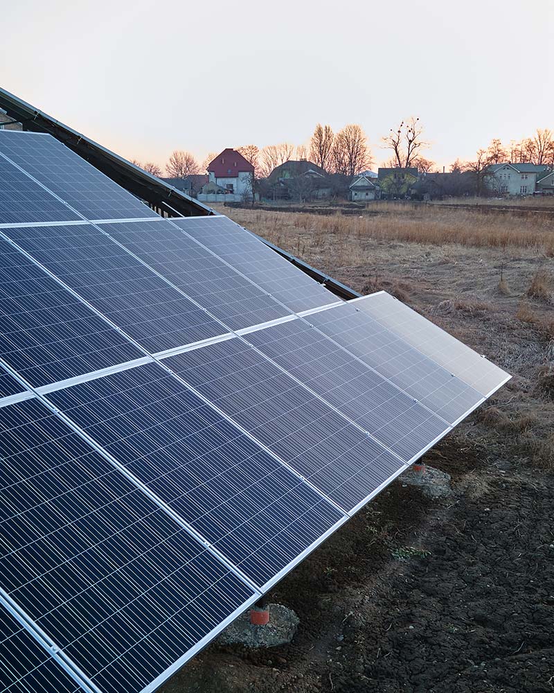 Angled view of solar panels at sunset, illustrating ground mount placement for Greenfield homes.