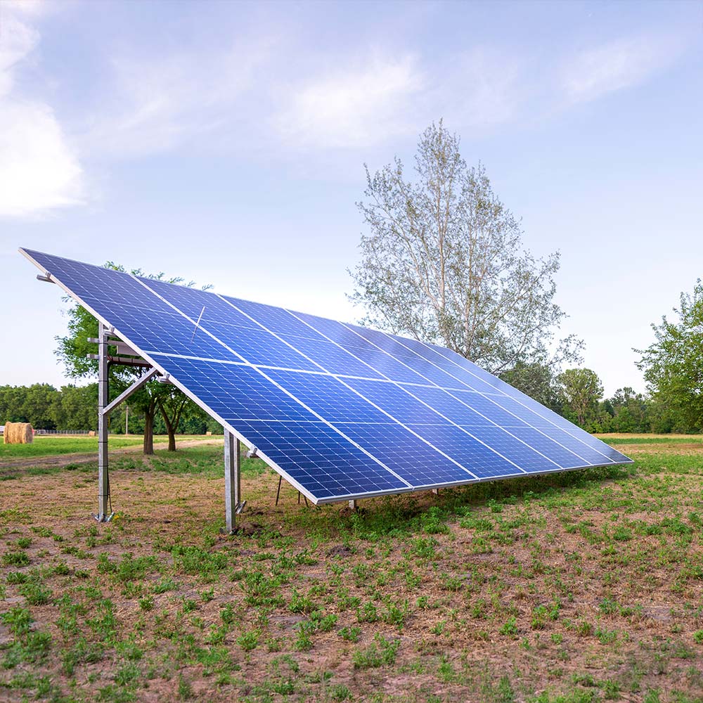 Freestanding solar array in an open field, typical of rural solar setups in Greenfield, MA.