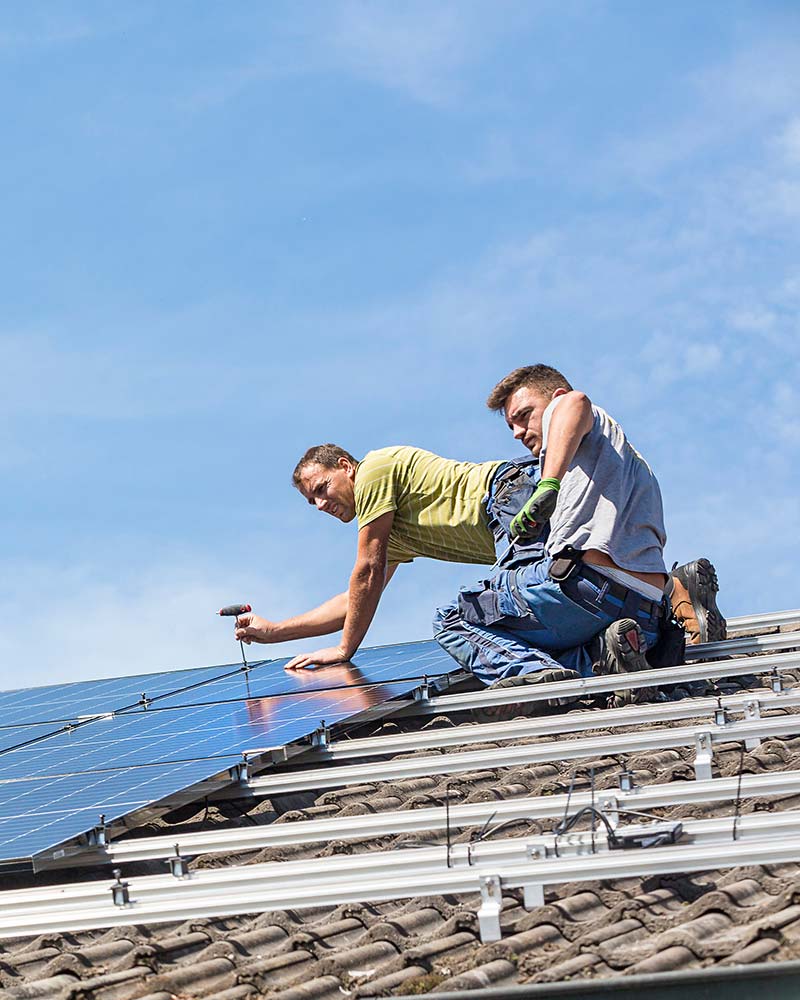 Residential solar installers fastening panels during a typical rooftop installation like those offered in Greenfield, MA.
