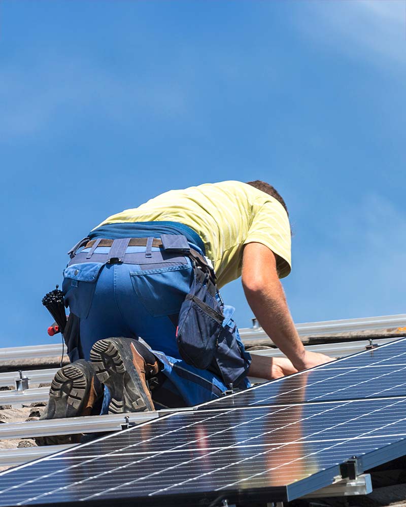 Solar installer on a residential roof installing solar panels