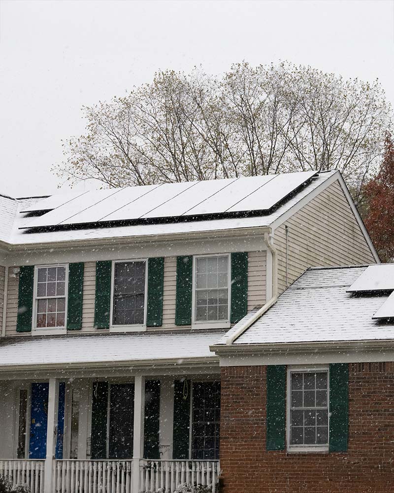 Western Massachusetts home with solar panels on the roof in the winter.
