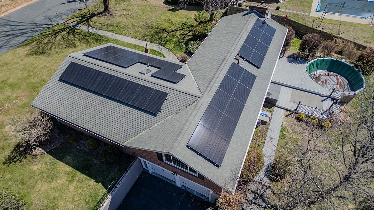 Home in Western Mass with rooftop solar panels, typical of Northampton and Amherst neighborhoods
