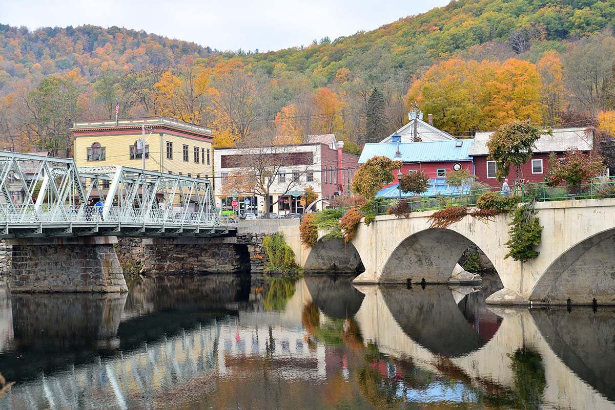 Bridge of Flowers in Shelburne Falls MA with historic bridge and village along the Deerfield River in autumn