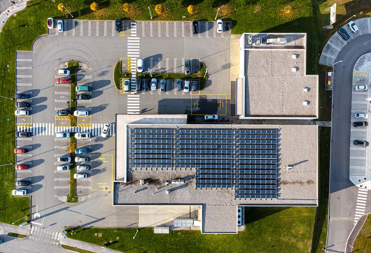 Commercial solar installation in Western Massachusetts on large rooftop with parking lot below