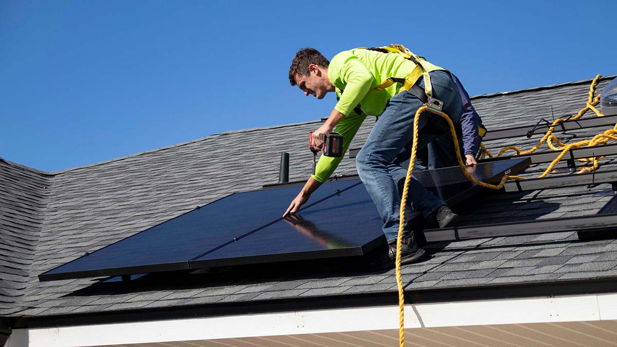 Wondering how long solar takes? An installer secures a residential solar panel during a rooftop installation in Western Massachusetts.