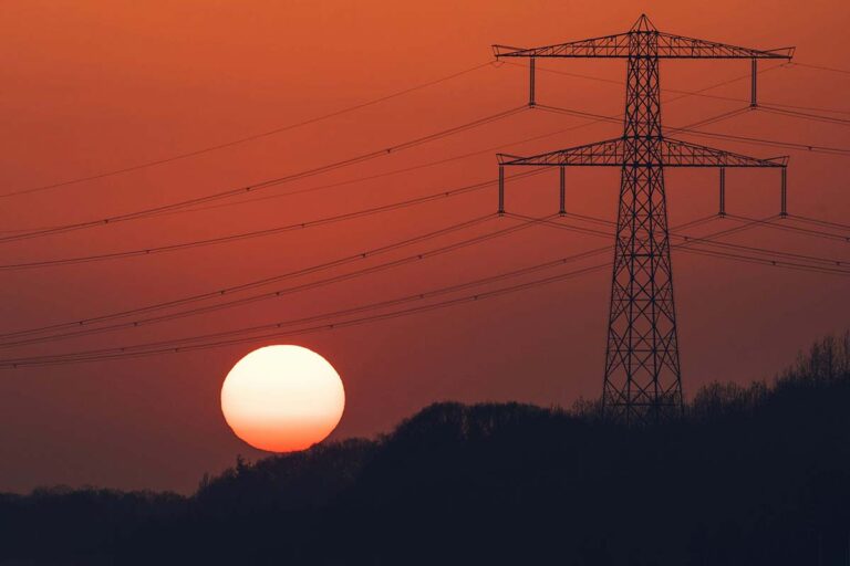 Powerlines with sinking sun as a metaphor for net metering.