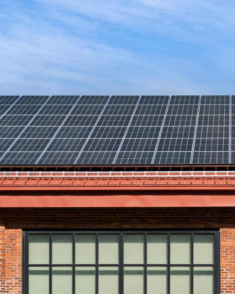 Commercial solar installation mounted on the roof of a brick mill building